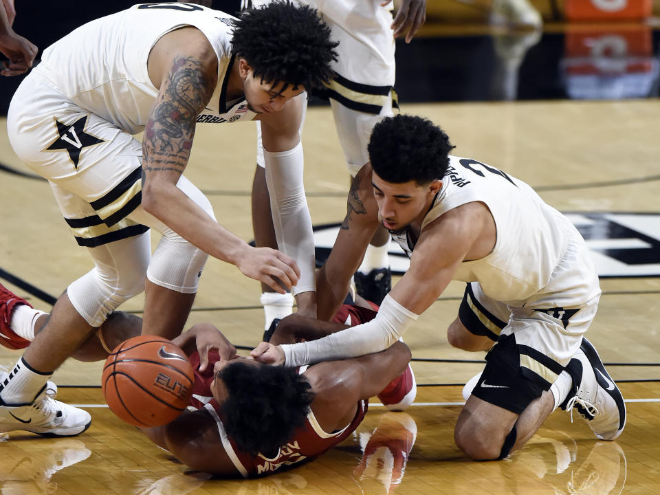 Vanderbilt forward Myles Stute, left, and guard Scotty Pippen Jr. (2) fight for the ball with Arkansas guard Moses Moody (5) during the second half of an NCAA college basketball game against Vanderbilt Saturday, Jan. 23, 2021, in Nashville, Tenn. Arkansas won 92-71. (AP Photo/Mark Zaleski)