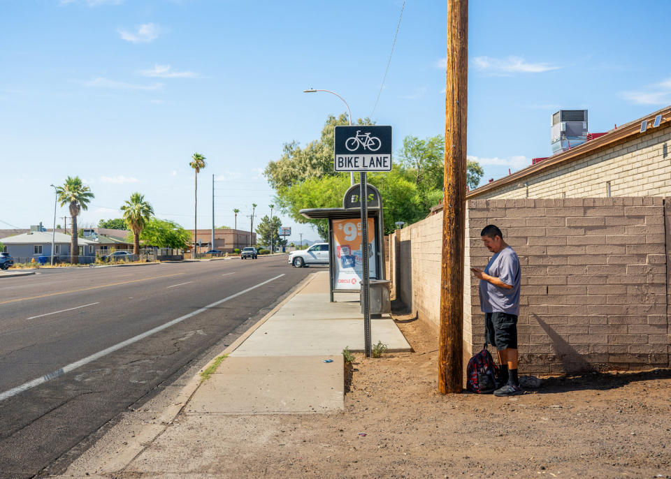 Image: Adrian Mata stands in the shade while waiting for the bus in Phoenix on July 15. (Brandon Bell / Getty Images file)