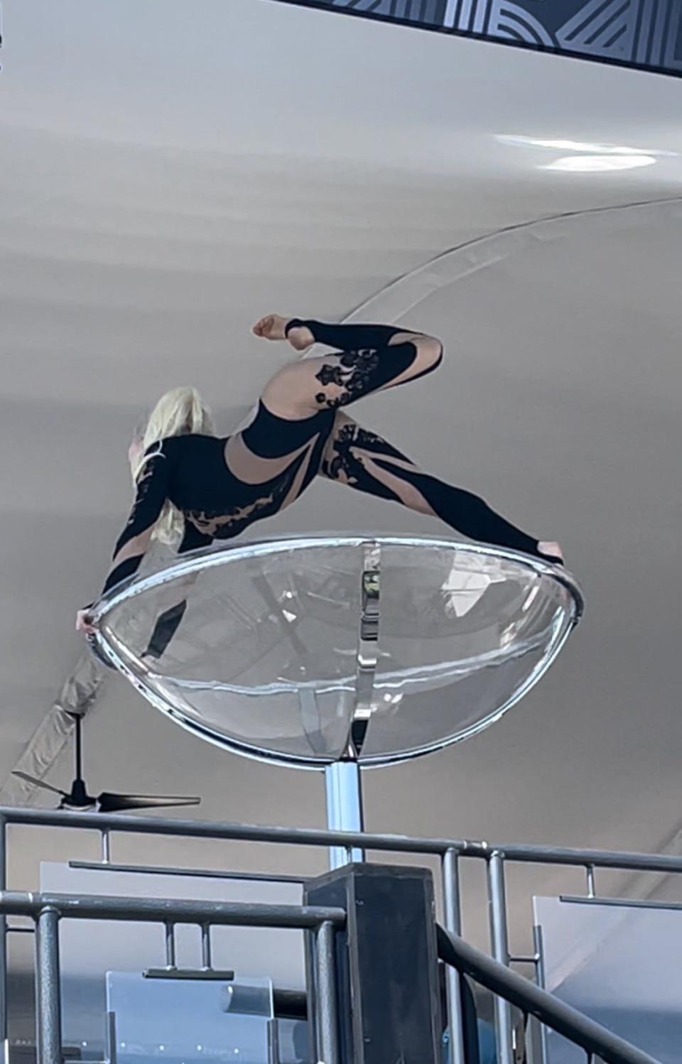 A woman dances in a giant champagne glass in the grandstands behind the 18th green at LIV Golf Miami.