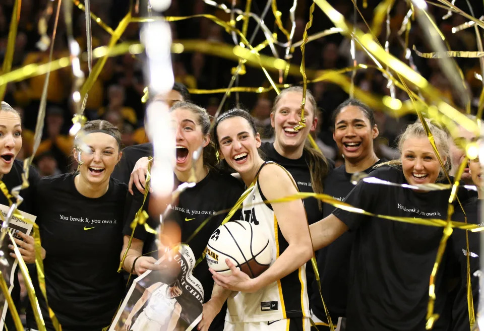 IOWA CITY, IOWA- FEBRUARY 15:  Guard Caitlin Clark #22 of the Iowa Hawkeyes celebrates with teammates during a presentation after breaking the NCAA women's all-time scoring record during the game against the Michigan Wolverines  at Carver-Hawkeye Arena on February 15, 2024 in Iowa City, Iowa.  (Photo by Matthew Holst/Getty Images)