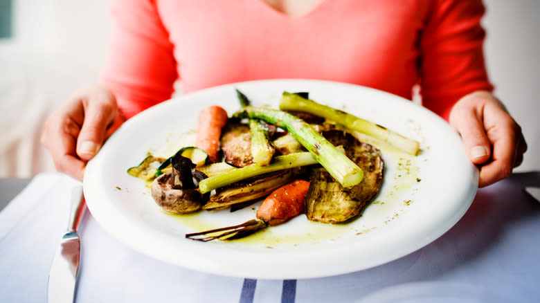 Woman sitting with a plate of veggies 