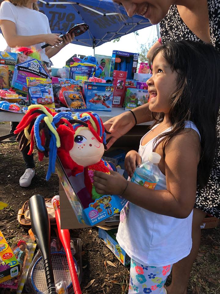 A young girl receives a toy at a toy drive held outside the Immigration and Customs Enforcement offices in Mirimar, Florida.