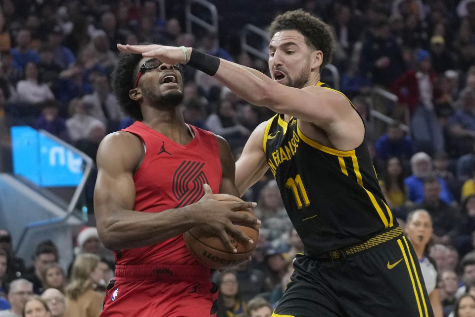 Portland Trail Blazers guard Scoot Henderson, left, drives to the basket against Golden State Warriors guard Klay Thompson (11) during the first half of an NBA basketball game in San Francisco, Saturday, Dec. 23, 2023. (AP Photo/Jeff Chiu)
