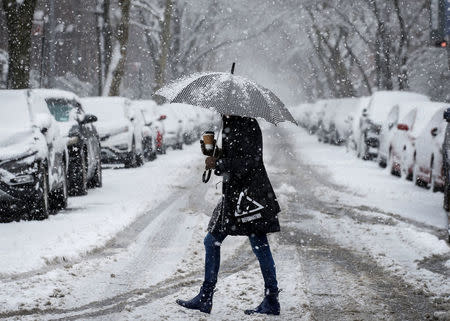 A woman walks in the snow during a winter nor'easter storm in the Brooklyn borough of New York, U.S., March 21, 2018. REUTERS/Brendan McDermid