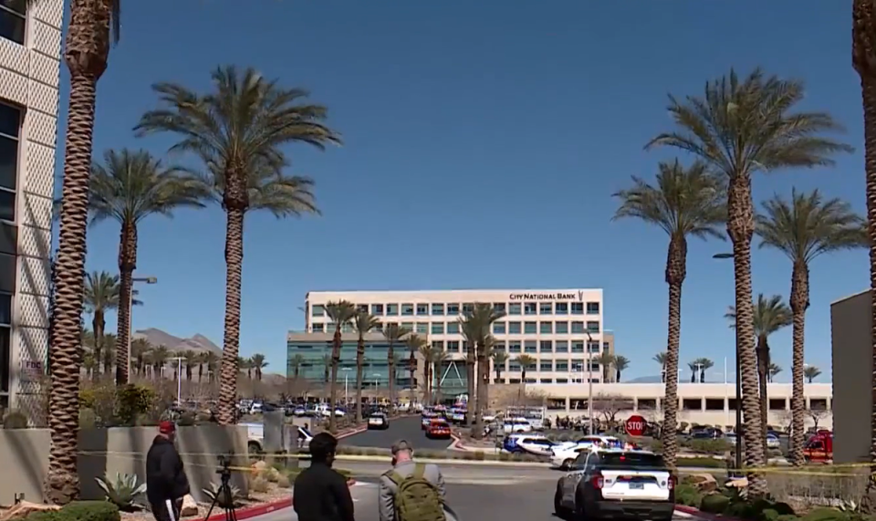 Police swarm the outside of the City National Bank following a shooting at a law firm office (8 News Now)