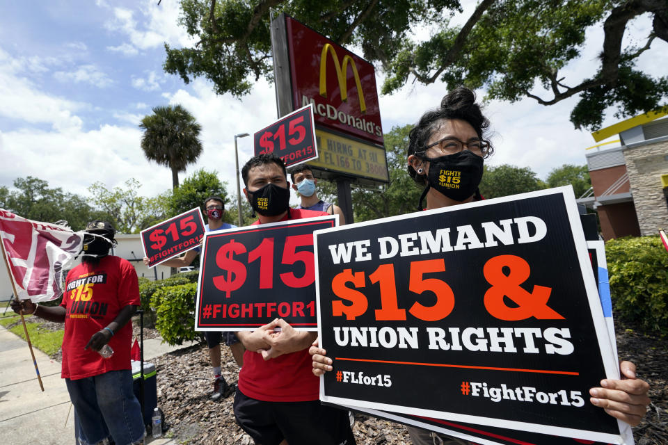 FILE - Workers and family members take part in a 15-city walkout to demand $15hr wages Wednesday, May 19, 2021, in front of a McDonald's restaurant in Sanford, Fla. From minimum wage increases to animal protection to police accountability to both cutting and increasing taxes a series of new laws are taking effect across the country on Saturday, Jan. 1, 2022. (AP Photo/John Raoux, File)