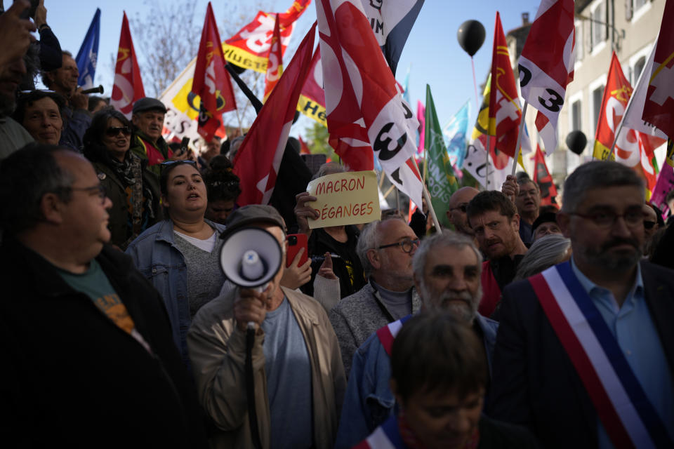 People demonstrate before French President Emmanuel Macron's visit, Thursday, April 20, 2023 in Ganges, southern France. The French leader tries to repair damage done to his presidency by forcing through unpopular pension reforms. Raising the retirement age from 62 to 64 has ignited a months-long firestorm of protest in France. (AP Photo/Daniel Cole)