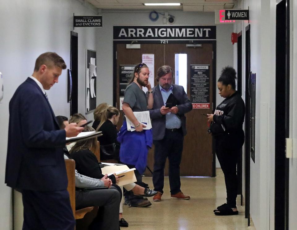 Landlord Ross Thomas, left, and his attorney Tyler J. Whitney speak in the hallway outside of the court of small claims and evictions in Akron.