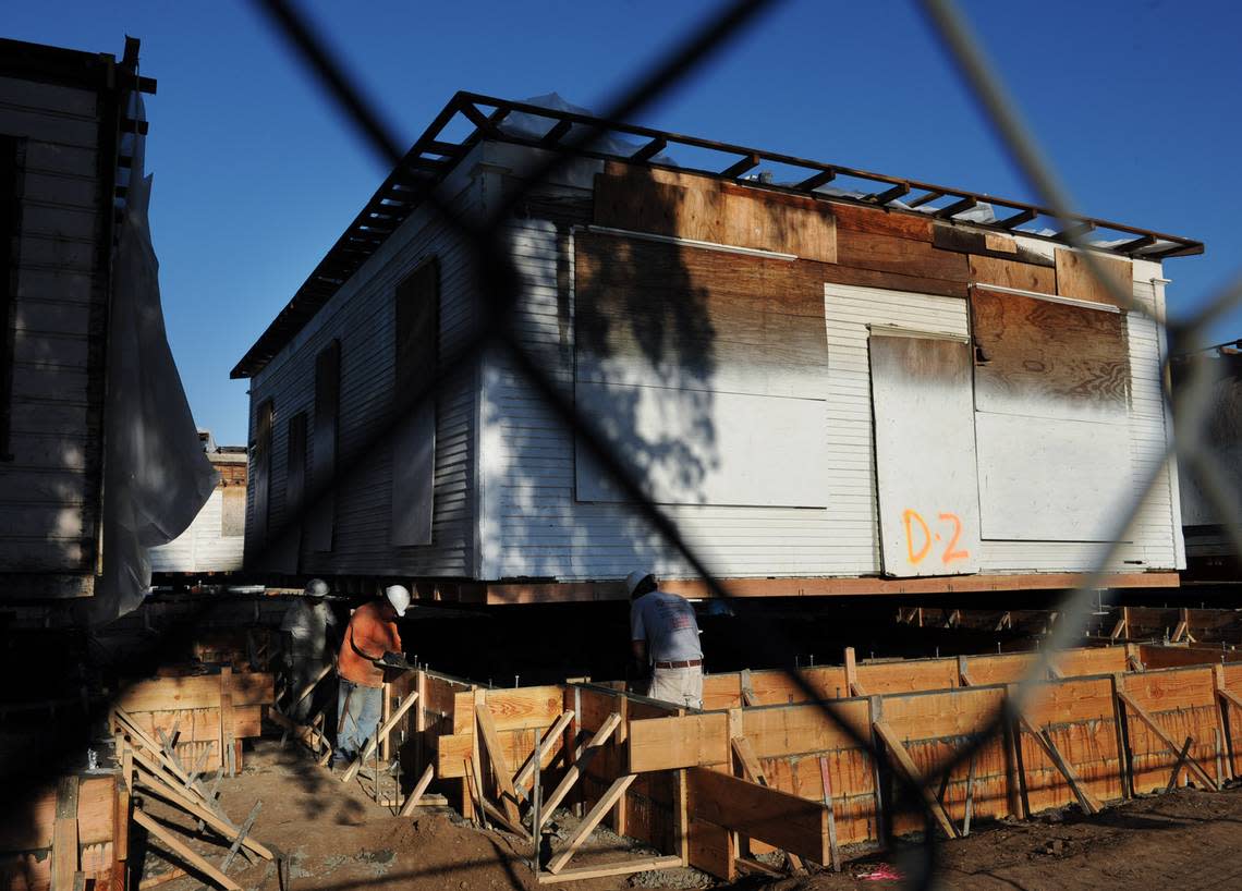 In February 2012, construction workers create a new concrete foundation for one of the five century-old houses relocated to the southeast corner of M and Santa Clara streets in downtown Fresno as part of the Old Armenian Town project.
