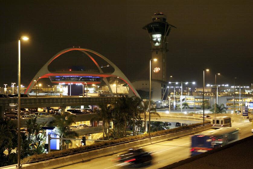 Traffic encircles the old futuristic Encounter restaurant (L) and the Los Angeles International Airport (LAX) control tower.