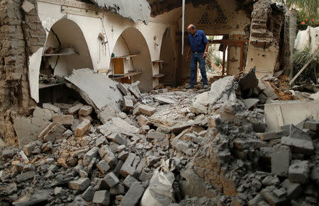 A Palestinian man inspects the arts and handcraft village that was damaged by Israeli air strikes in Gaza City July 15, 2018. REUTERS/Suhaib Salem