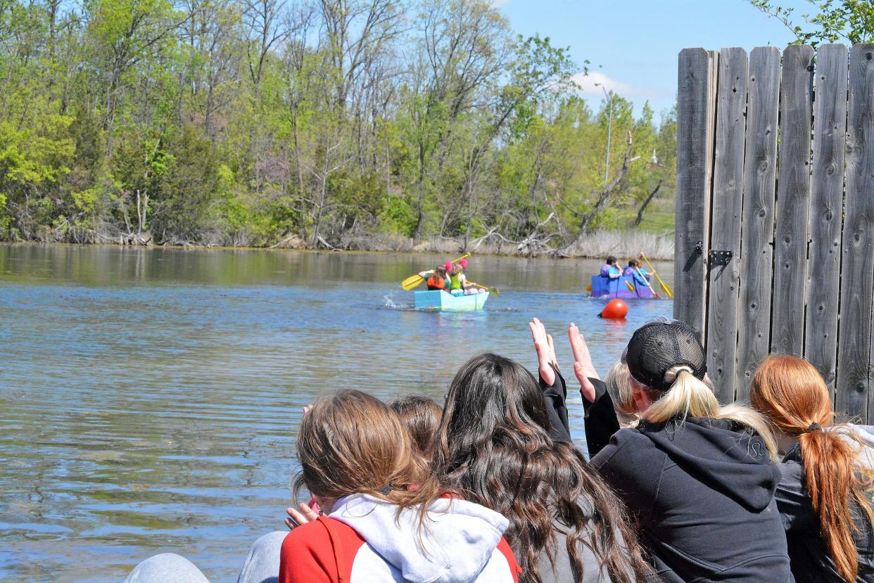 Spectators watch Saturday as cardboard boats named 'The Water Lily' and 'Bo Da Boat' compete in the annual Food Bank for Central and Northeast Missouri Float Your Boat competition at Bass Pro Shops lake.