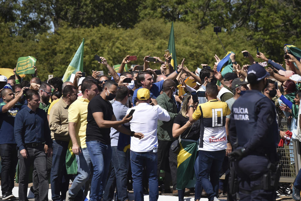 El presidente de Brasil, Jair Bolsonaro, saluda a los partidarios reunidos fuera del palacio presidencial en Brasilia, el domingo 31 de mayo de 2020. (Foto AP/Andre Borges)