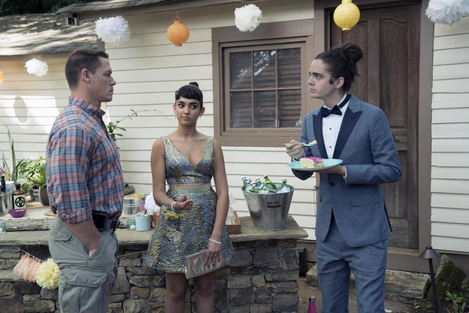 A stern father talks to his daughter's prom date as he eats cake