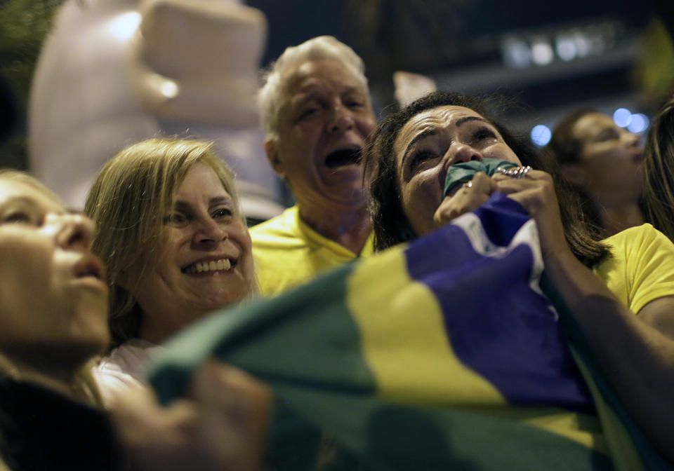 A supporter of Jair Bolsonaro cries tears of joy after he was declared the winner of the election runoff, during a celebration in front of his residence in Rio de Janeiro, Brazil, Sunday, Oct. 28, 2018 . Bolsonaro, a brash far-right congressman who has waxed nostalgic for Brazil's old military dictatorship, won the presidency of Latin America's largest nation Sunday as voters looked past warnings that the former army captain would erode democracy and embraced a chance for radical change after years of turmoil. (AP Photo/Silvia Izquierdo)