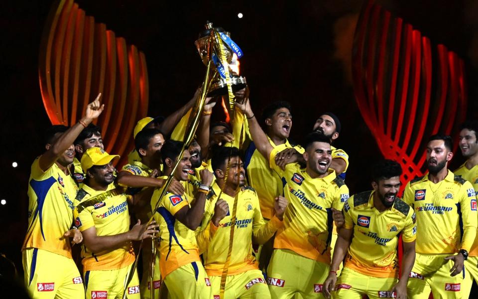 Chennai Super Kings' players celebrate with the trophy after their victory against Gujarat Titans in the Indian Premier League final - AFP/SAJJAD HUSSAIN
