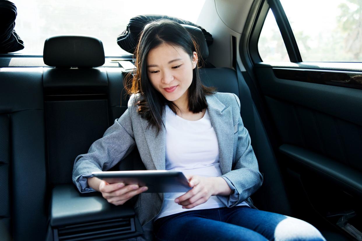 Businesswoman using digital tablet in car