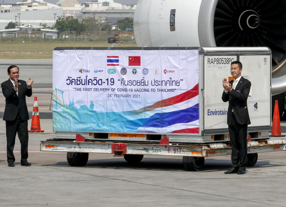 Prime Minister Prayuth Chan-ocha, left, and Yang Xin, right, Charge d'Affaires of China embassy of Thailand clap during a ceremony to mark the arrival of 200,000 doses of the Sinovac vaccine shipment at Suvarnabhumi airport in Bangkok, Thailand, Wednesday, Feb. 24, 2021. Thailand is scheduled to receive first shipments of 200,000 doses of the Sinovac vaccine and 117,000 doses of the AstraZeneca vaccine on Feb. 24. (AP Photo/Sakchai Lalit)