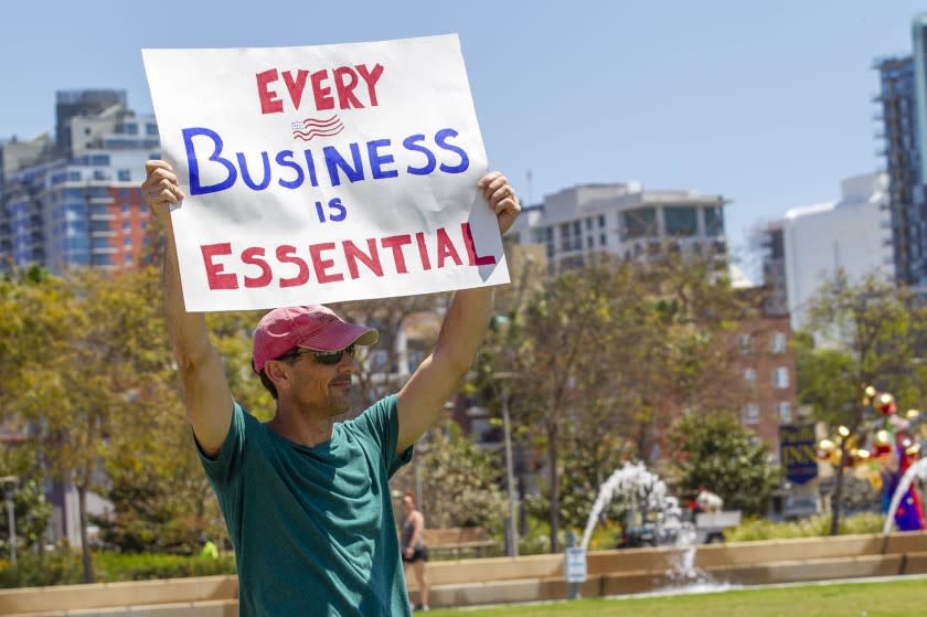 Brian Tinney, an IT contractor, is himself working but worried about all of the small businesses that are being forced to stay closed even though he thinks they could be open and working smart to avoid the spread of COVID_19. About 50 people participated in a protest organized by the Facebook Group "Liberate San Diego" at the corner of Harbor Drive and Grape Street near the county administration on Friday, April 24, 2020, urging elected officials to start a reopening of the economy.