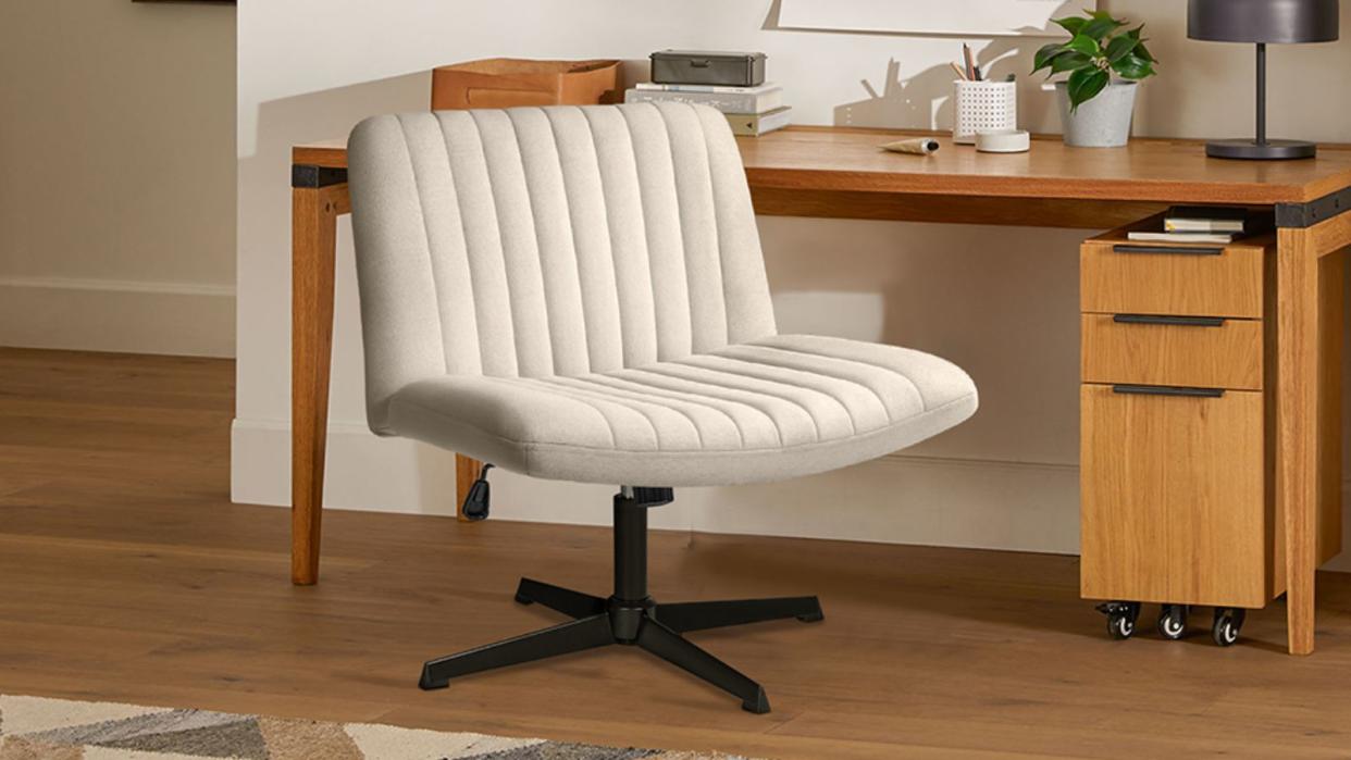  AKA the Amazon criss-cross chair, the  Pukami Armless Office Desk Chair sits in front of a midcentury wooden desk. 