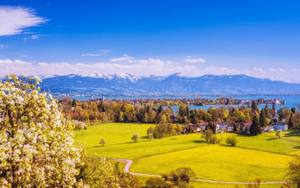 View across the island of Lindau to the Austrian Alps in the distance - Juergen Sack/Getty