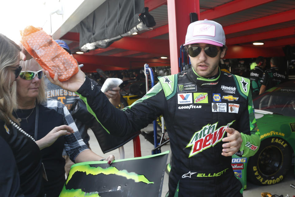 Chase Elliott hands a signed toy back to a fan as he enters the garage at Martinsville Speedway In Martinsville, Va., Saturday, Oct. 26, 2019. Elliott had an engine failure less than five minutes into the opening practice for the third round of NASCAR's playoffs. (AP Photo/Steve Helber)