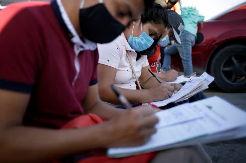 Job seekers fill out job application forms for assembly factories as the coronavirus disease (COVID-19) outbreak continues in Ciudad Juarez