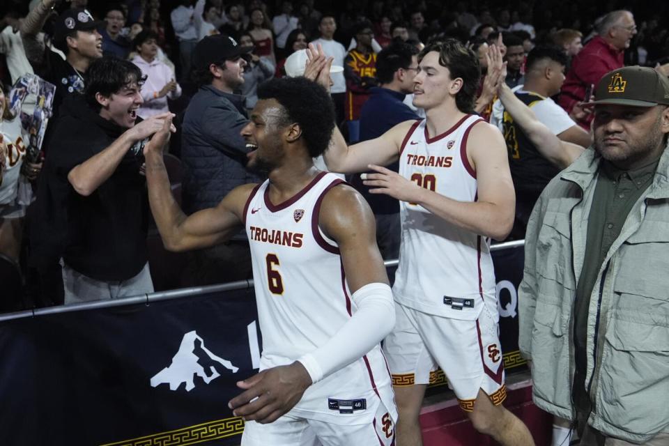 USC guard Bronny James and forward Harrison Hornery celebrate with fans after the team's win over Arizona