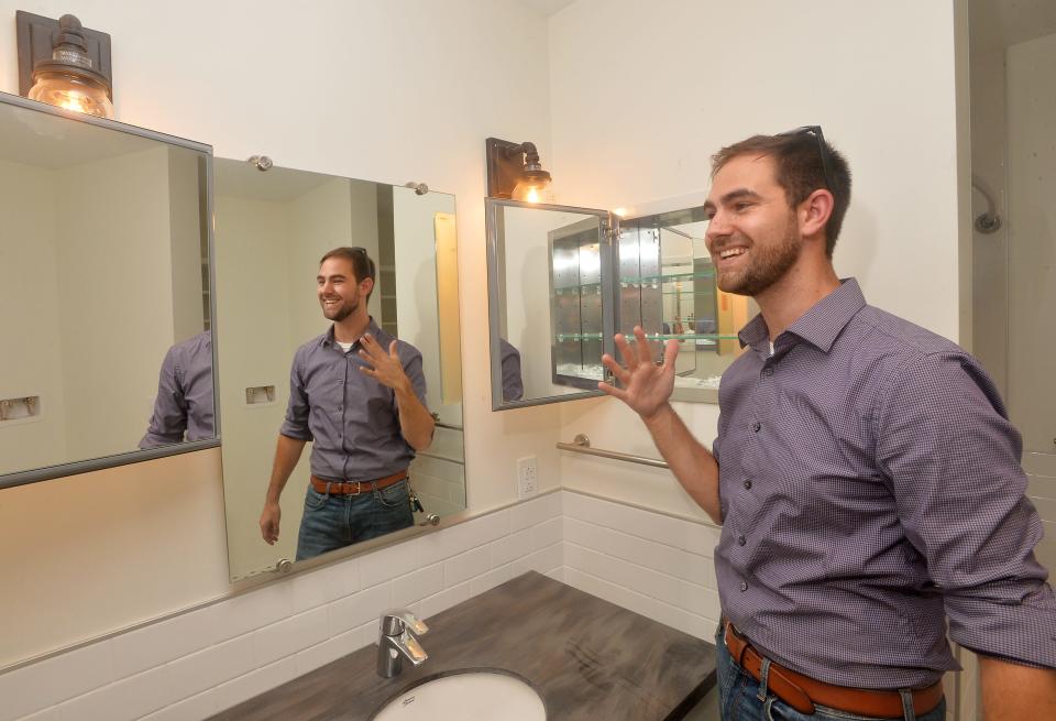 Erie Downtown Development Corporation's Ryan Hoover jokes about the mirrors in an apartment in a renovated downtown building in this July 2021 photo.