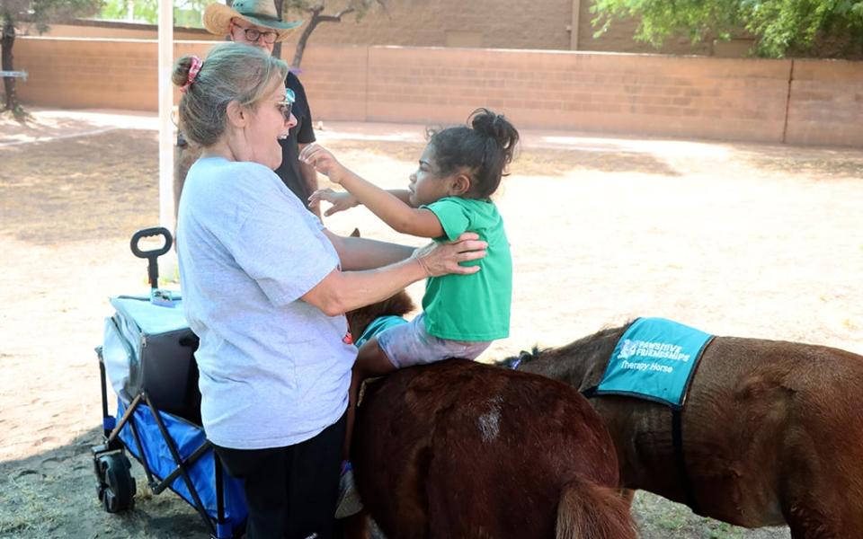 A Place 4 Everyone Learning Center staff member Tori Rimmer and student engage with therapy miniature horses Dante and Daphne. (Hunter Fore/Cronkite News)