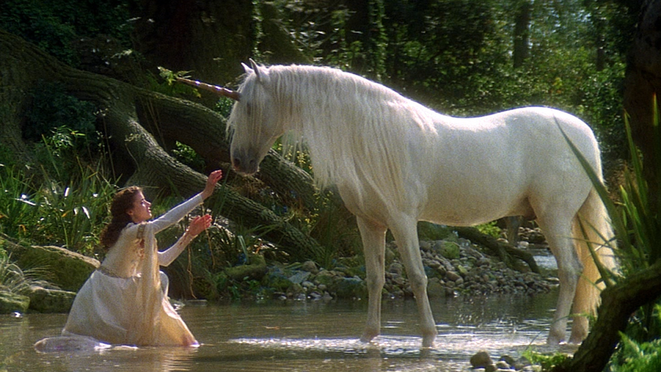 A white-dressed maiden sits in the water with a white horse.