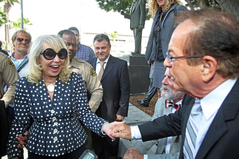 Shelly Sterling, left, greets Max Blecher, attorney for her estranged husband Donald Sterling, after a judge ruled in her favor and against her husband in his attempt to block the $2 billion sale of the Los Angeles Clippers, outside Los Angeles Superior Court Monday, July 28, 2014. (AP Photo/Nick Ut)