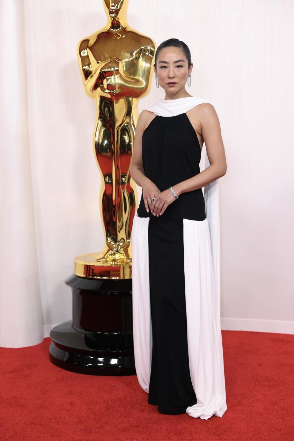 Greta Lee wears a black and white dress.