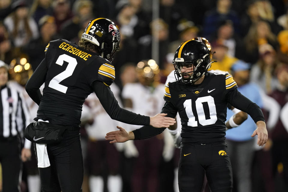 Iowa place kicker Caleb Shudak (10) celebrates with teammate Ryan Gersonde (2) after kicking a 29-yard field goal during the second half of an NCAA college football game against Minnesota, Saturday, Nov. 13, 2021, in Iowa City, Iowa. Iowa won 27-22. (AP Photo/Charlie Neibergall)