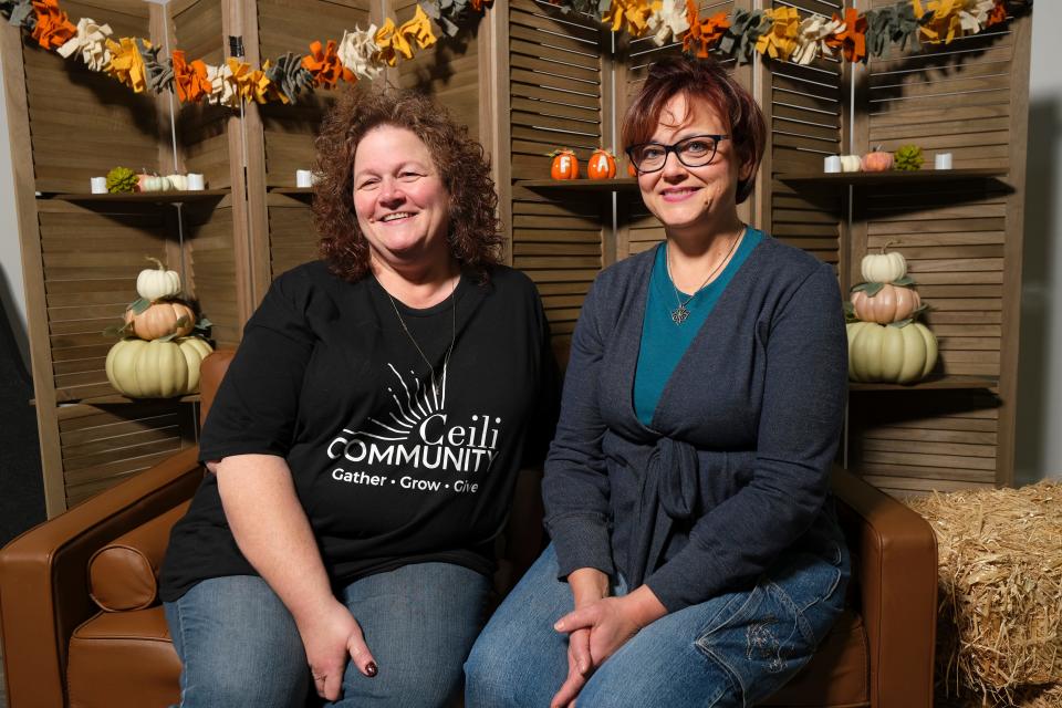 Members Alicia Holmes and Amy Marcum sit in front of a fall display at the Ceili Community, a new United Methodist church in the southwest Oklahoma City/Mustang area.