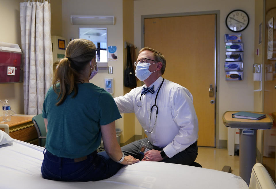 Kathleen Jade is examined by Dr. Will Gwin before receiving her third dose of an experimental breast cancer vaccine at University of Washington Medical Center - Montlake, Tuesday, May 30, 2023, in Seattle. Jade, 50, learned she had breast cancer in late February. She's getting the vaccine to see if it will shrink her tumor before surgery. “Even if that chance is a little bit, I felt like it’s worth it," said Jade, who is also getting standard treatment. (AP Photo/Lindsey Wasson)