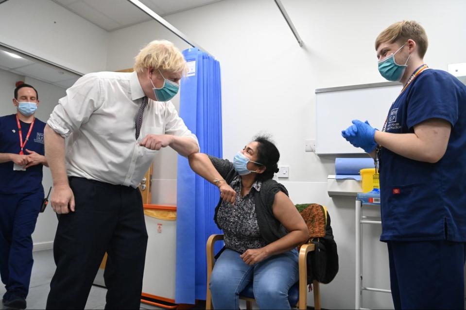 Prime Minister Boris Johnson greets a patient receiving a vaccine with an elbow bump during a visit to Lordship Lane Primary care Centre in north London to meet staff and see people receiving their booster vaccines on Tuesday (PA)