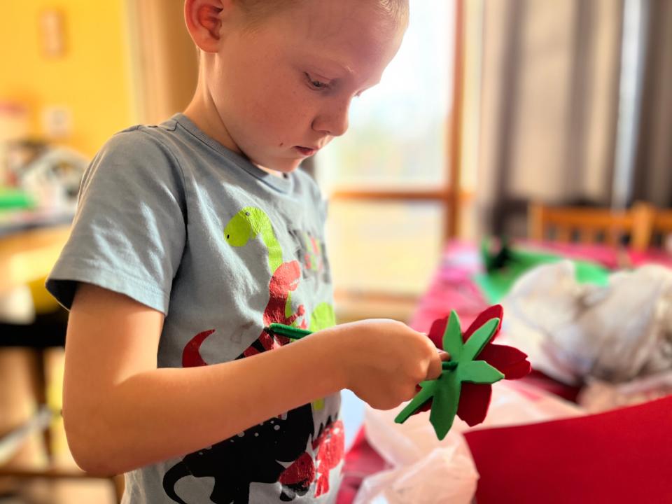 lisa's kid making a poinsettia craft in their home