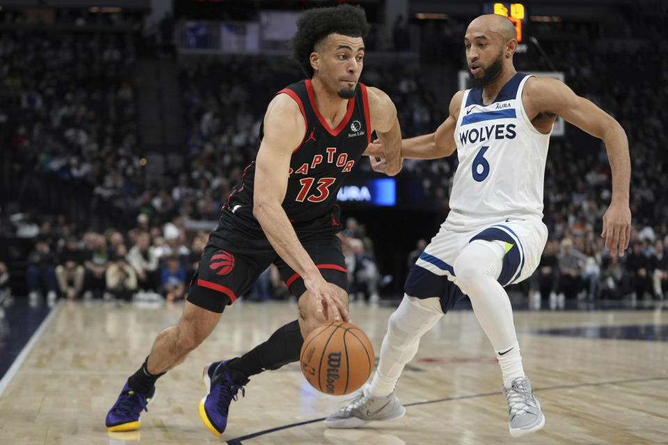 Toronto Raptors forward Jordan Nwora (13) works toward the basket as Minnesota Timberwolves guard Jordan McLaughlin (6) defends during the first half of an NBA basketball game, Wednesday, April 3, 2024, in Minneapolis. (AP Photo/Abbie Parr)