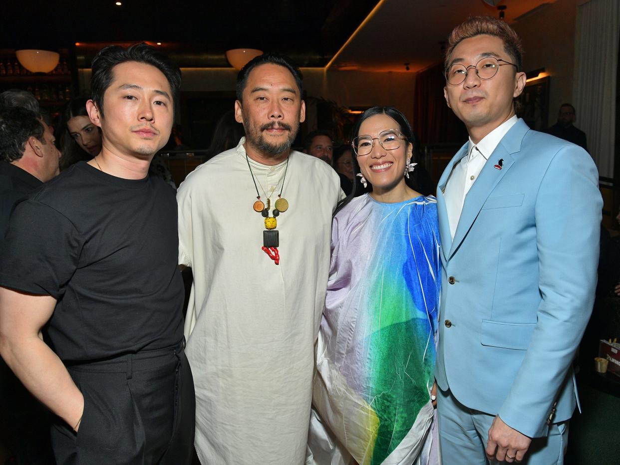 steven yeun, david choe, ali wong, and lee sung jin at the los angeles premiere of beef. they are standing in a row, smiling and holding their arms around each other in a party room