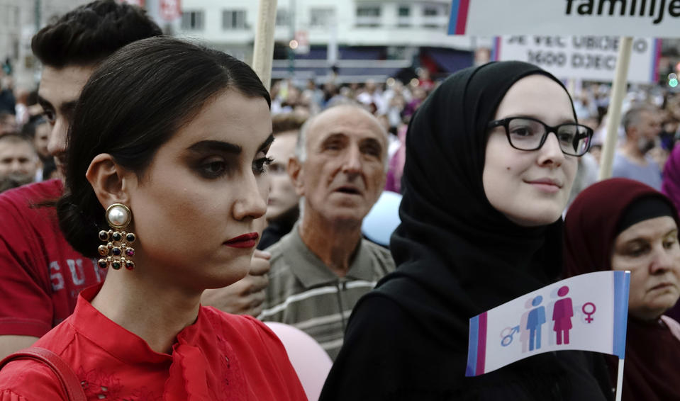 A woman holds a banner as she takes part in what was said was a gathering designed to promote traditional family values in Sarajevo, Bosnia, Saturday, Sept. 7, 2019. Several hundred people have marched in Bosnia's capital Sarajevo to express their disapproval of the Balkan country's first ever LGBT pride parade scheduled for Sunday. (AP Photo/Eldar Emric)