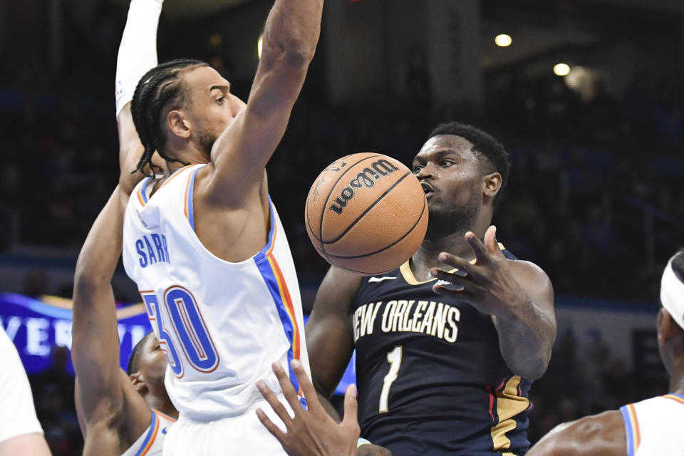 New Orleans Pelicans forward Zion Williamson (1) passes the ball around Oklahoma City Thunder center Olivier Sarr (30) in the second half of an NBA basketball game, Wednesday, Nov. 1, 2023, in Oklahoma City. (AP Photo/Kyle Phillips)