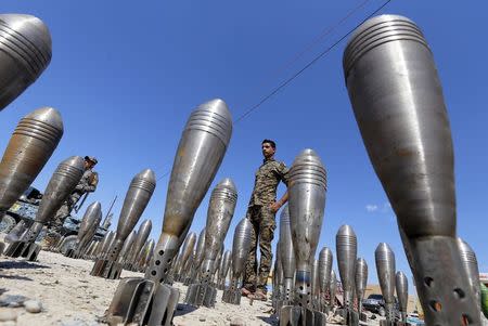 A member of the Iraqi security forces stands between Islamic State ammunition being displayed in al-Alam Salahuddin province, Iraq in this March 17, 2015 file photo. REUTERS/Thaier Al-Sudani/Files