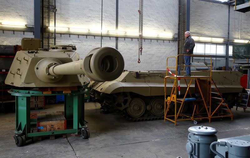 Kubicki stands beside the hull of a German World War II Tiger II "King Tiger" tank during restoration works at Swiss Military Museum Full in Full