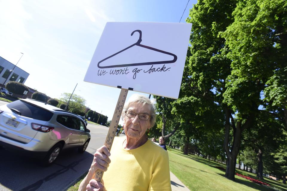 Carolyn Holley, 83, holds a sign displaying a coat-hanger during a rally for abortion rights at Pine Grove Park in Port Huron on Friday, June 24, 2022. The rally was organized following the long-expected decision from SCOTUS overturning Roe vs. Wade.