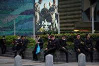 Security guards rest outside a shopping mall at financial district of Lujiazui in Shanghai