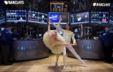 Dancers from the New York City Ballet's production of "The Nutcracker" pose for photos on the floor of the New York Stock Exchange on Christmas Eve in New York, December 24, 2013. REUTERS/Carlo Allegri