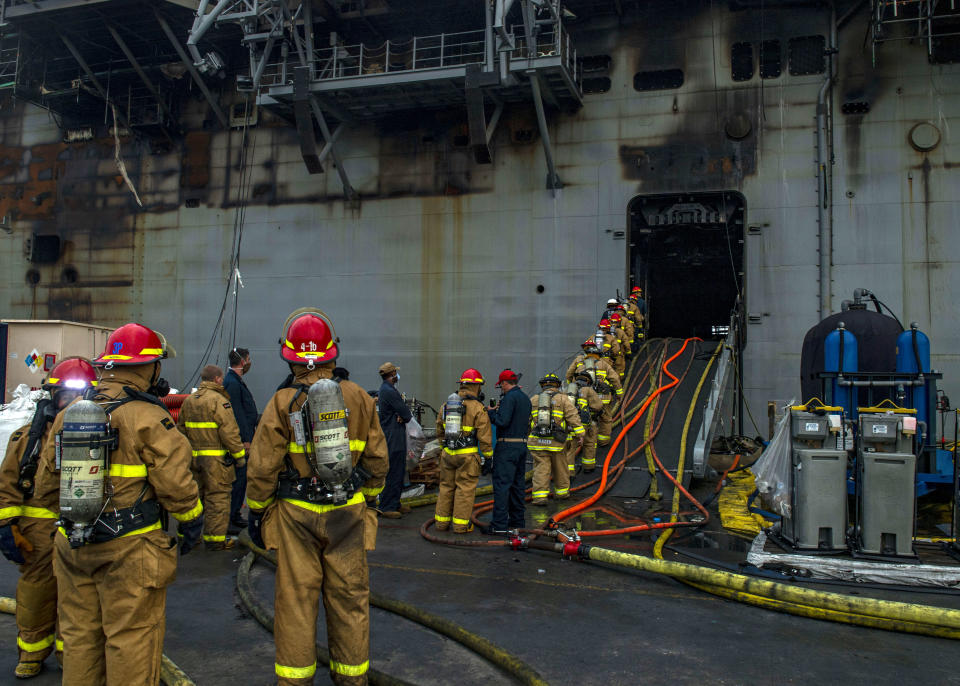 Sailors prepare to board the amphibious assault ship USS Bonhomme Richard (LHD 6) to fight an ongoing fire at Naval Base in San Diego, Calif. on Tuesday, July 14, 2020. The fight to save a burning Navy warship docked in San Diego has entered a third day with indications of improvement. A Navy statement says there's been significant progress and much less smoke is being emitted from the USS Bonhomme Richard on Tuesday. (Mass Communications Specialist 3rd Class Jason Waite/U.S. Navy via AP)