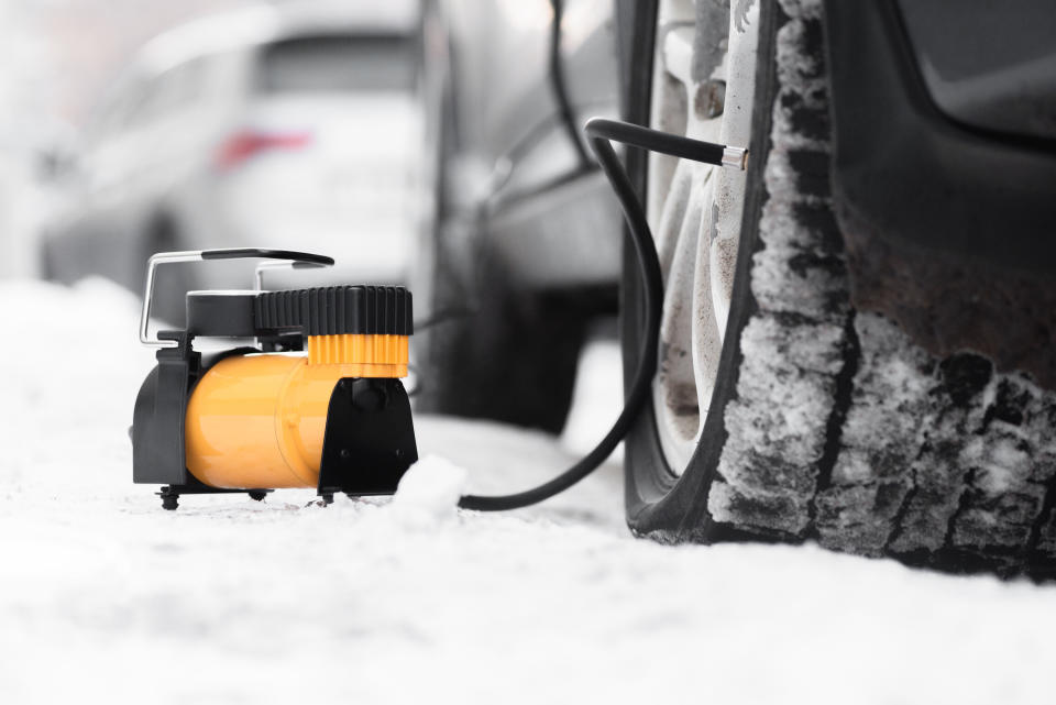 Car air pump and empty automobile wheel close up background.