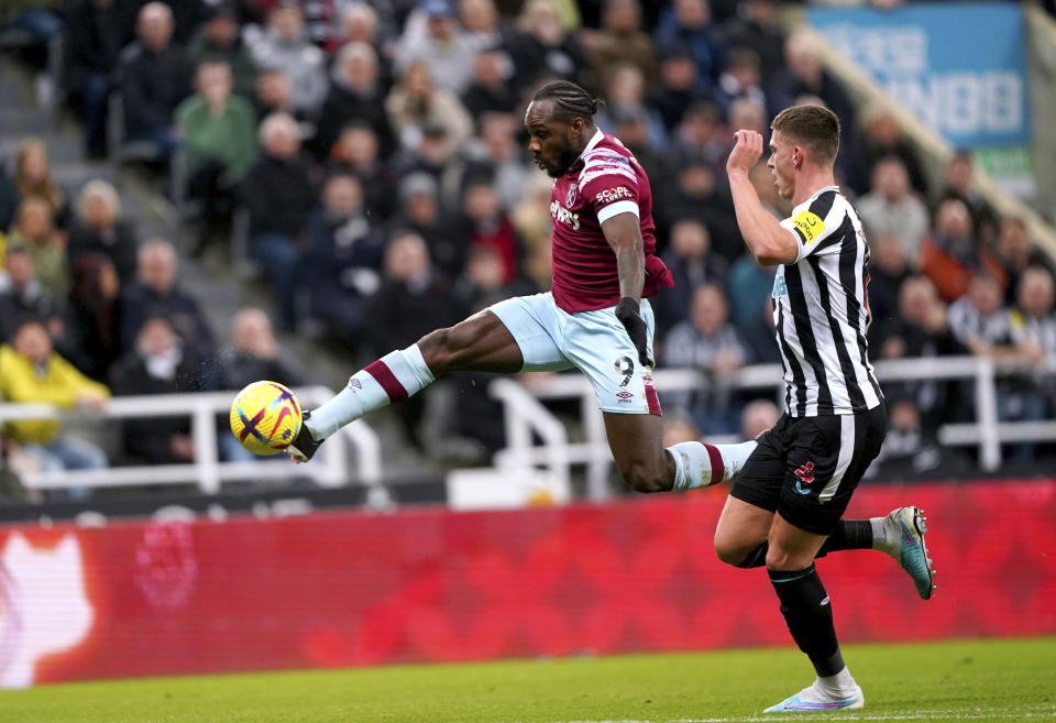 West Ham United's Michail Antonio, left and Newcastle United's Sven Botman battle for the ball , during the English Premier League soccer match between Newcastle United and West Ham United, at St. James' Park, in Newcastle upon Tyne, England, Saturday, Feb. 4, 2023. (Owen Humphreys/PA via AP)